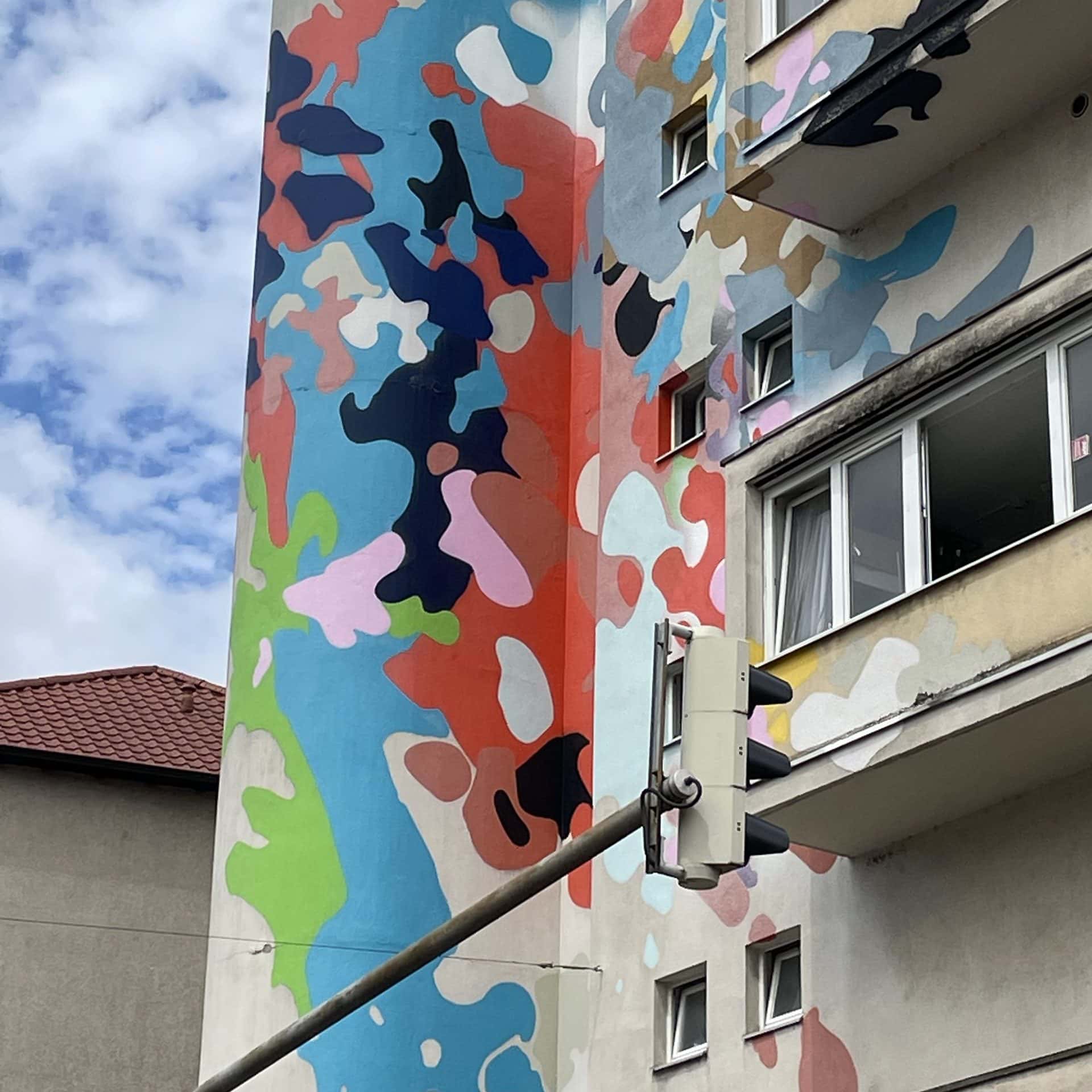 Wohnhaus mit großflächigem, buntem Fleckenmuster an der Fassade