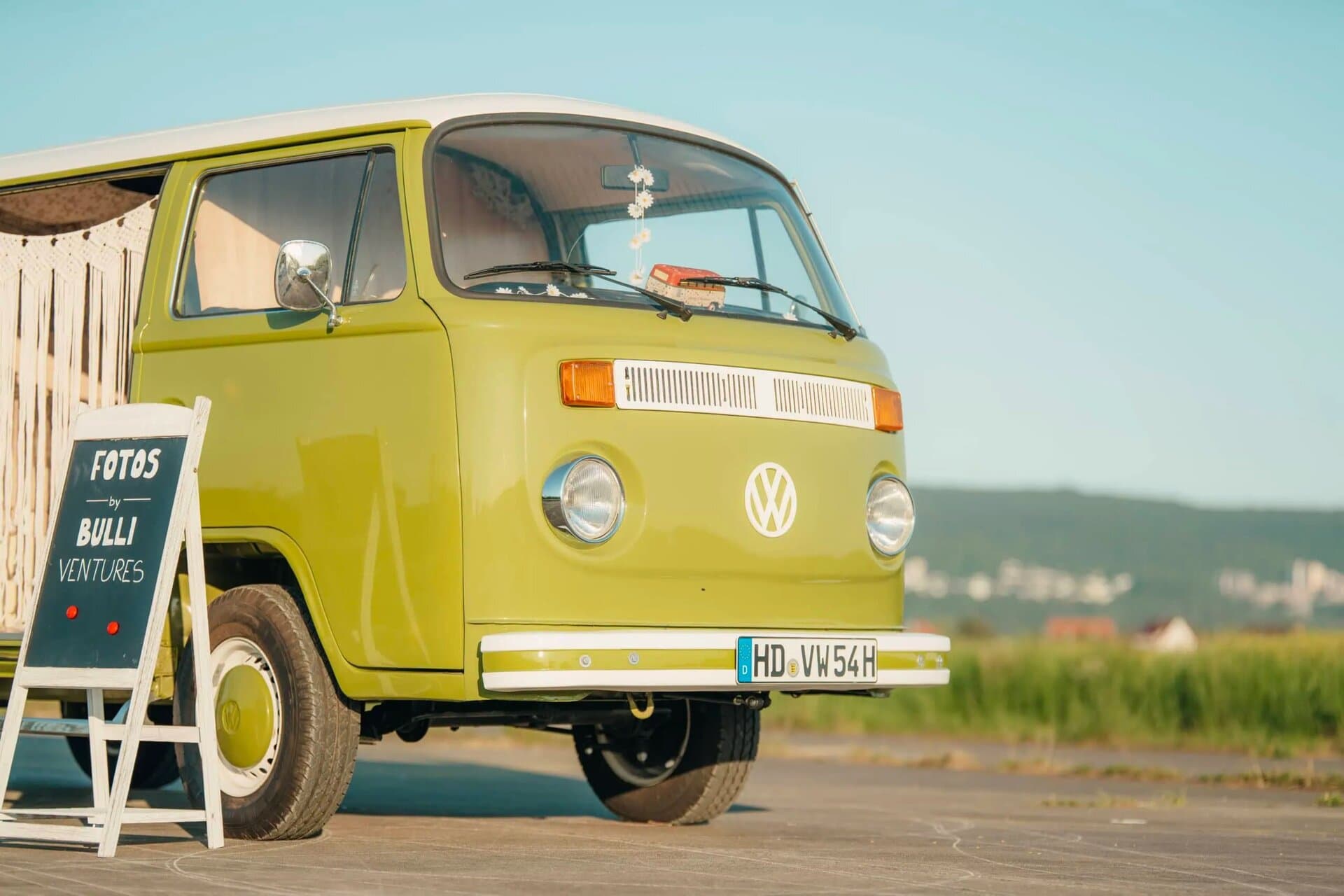Grüner VW Bulli von Bulli Ventures mit Aufsteller für Fotos