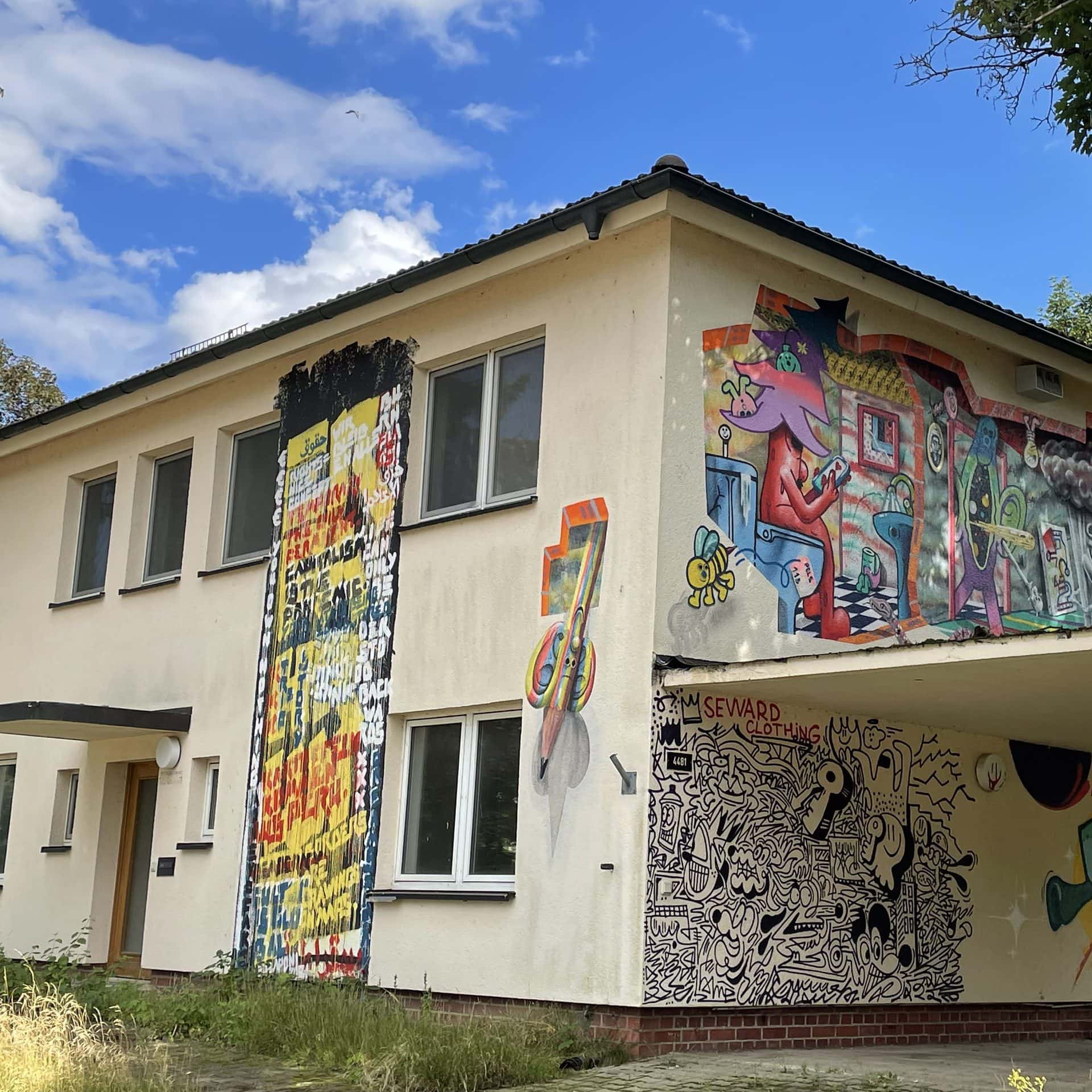 Ehemaliges Wohngebäude mit mehreren Street-Art-Wandbildern