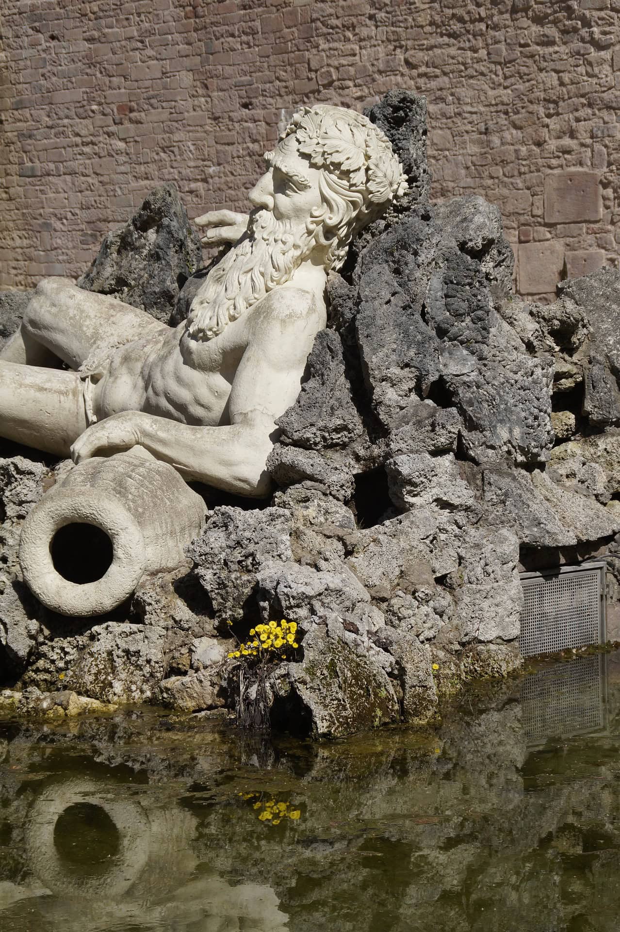 Liegende Flussgott-Figur an einem Brunnen im Heidelberger Schlossgarten