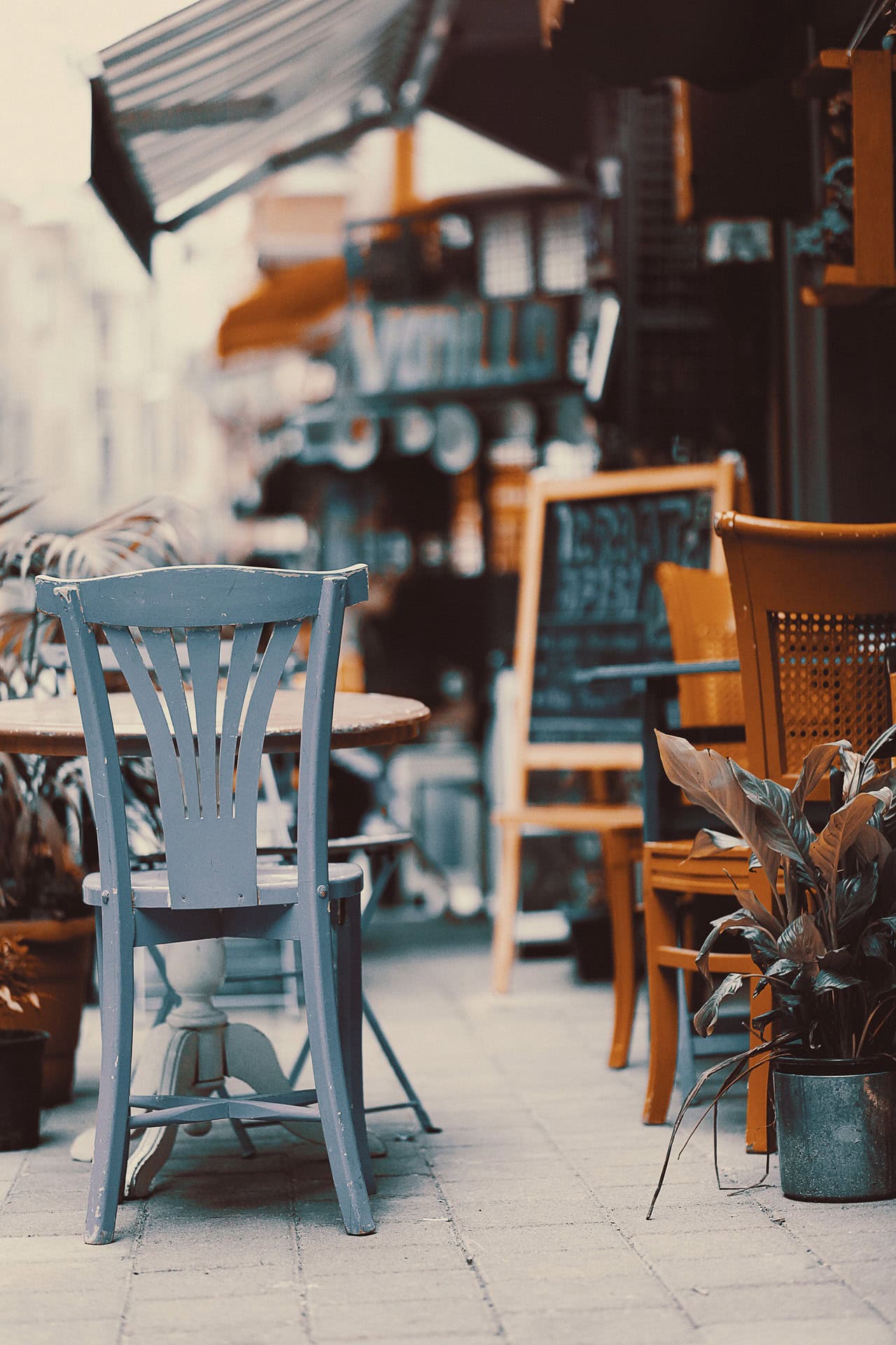 Stühle und Tische vor einem Straßencafé