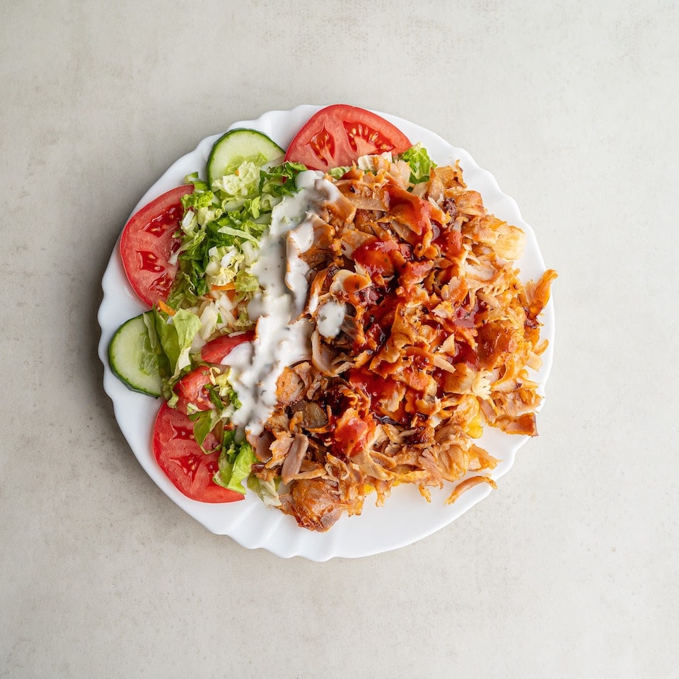Dönerteller mit Salat, Tomaten, Gurken und Soße