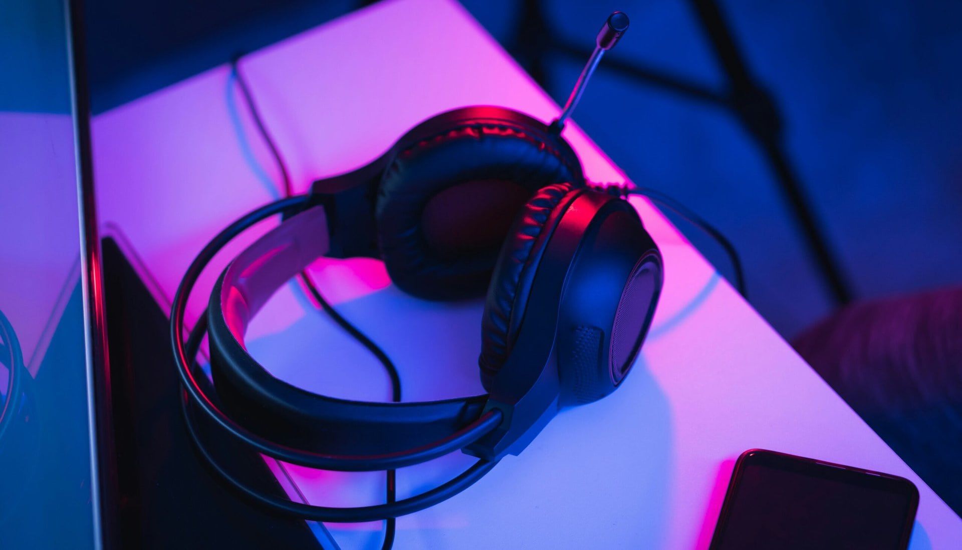 Gaming-Headset auf einem Schreibtisch in Neonlicht