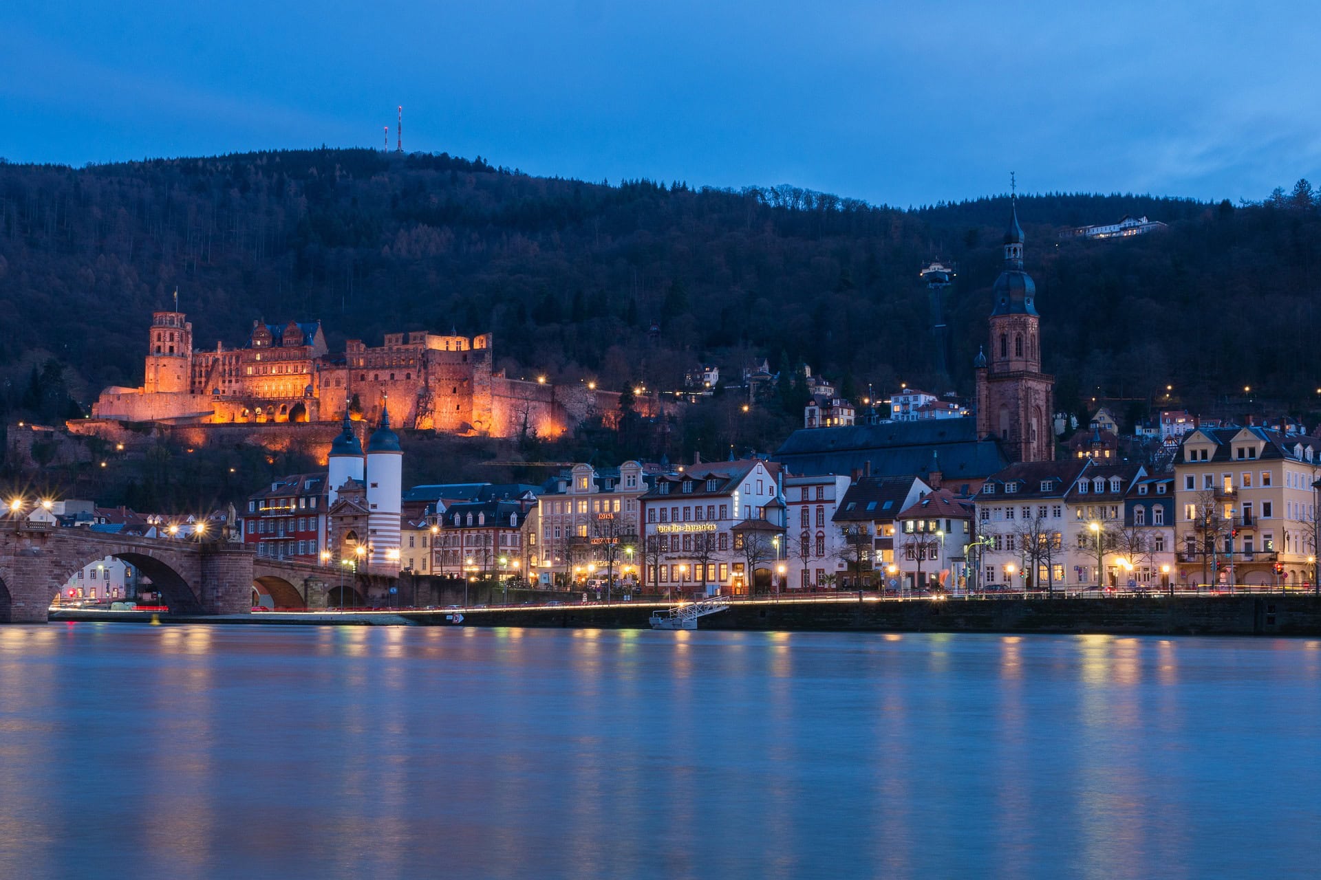 Beleuchtetes Heidelberger Schloss und Altstadt am Abend, vom Neckar aus gesehen